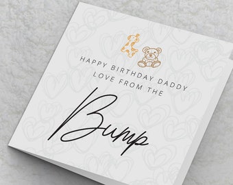 May include: White card with a light gray background and a black handwritten message that says "Happy Birthday Daddy Love from the Bump". The card is decorated with small, light gray hearts and two gold icons of a giraffe and a teddy bear.