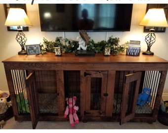 May include: Triple door dog crate made of red oak wood. The crate has three equal units, each measuring 24 x 22.5 x 30 inches. The crate is shown in a living room setting with a television and lamps.