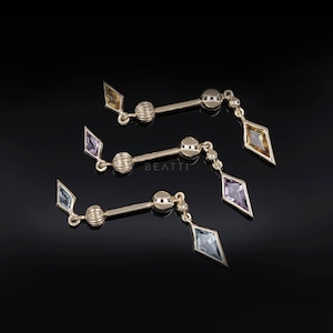 May include: Three pairs of gold-coloured earrings with a bar design. Each earring features a central sphere, a small diamond-shaped gem, and a larger, dangling diamond-shaped gem in shades of yellow, purple, and blue. The earrings are displayed against a black background.