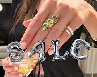 Olijfkleurige martini ring, ovale ring met drie stenen in een spanningszetting, goudkleurige cocktailring