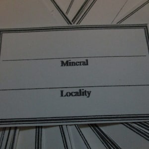 May include: A blank white label with a black border and the words "Mineral" and "Locality" printed on it.