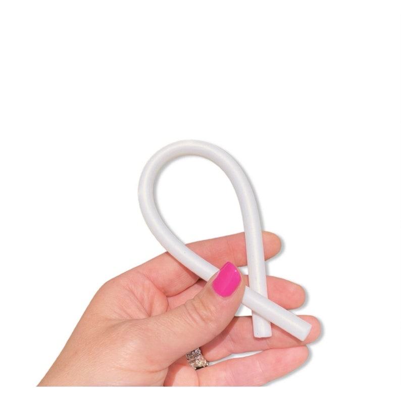 Puede incluir: Un tubo de silicona blanco flexible, doblado en forma de bucle.