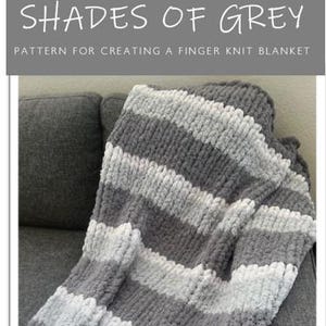 Puede incluir: Una manta de punto de dedo a rayas grises y blancas. La manta está hecha con un hilo grueso y tiene una textura suave y esponjosa. El texto "SHADES OF GREY" y "PATTERN FOR CREATING A FINGER KNIT BLANKET" se muestra sobre la manta.