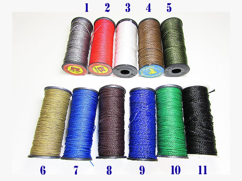 May include: An assortment of eleven spools of waxed nylon cord in various colors. The colors include silver, red, white, brown, olive green, tan, blue, dark brown, bright blue, green, and black. Each spool is labeled with a number from 1 to 11.