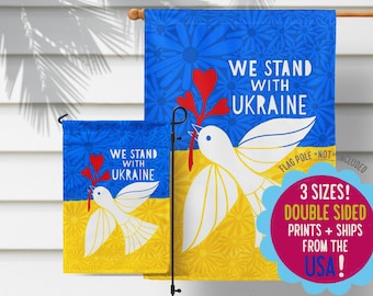 Puede incluir: Dos banderas de jardín de doble cara con una paloma blanca que lleva corazones rojos y el texto "We Stand With Ukraine". Las banderas son azules y amarillas, los colores de la bandera ucraniana.