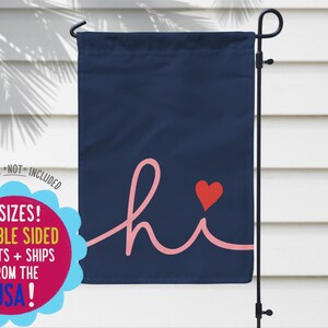 Pode incluir: Uma bandeira de jardim azul marinho com a palavra "hi" em escrita rosa e um cora&ccedil;&atilde;o vermelho. A bandeira tem o texto "3 tamanhos! Impress&otilde;es dupla face + envios dos EUA!" em um c&iacute;rculo rosa e azul.