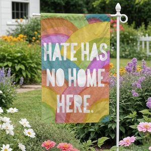 Könnte beinhalten: Eine farbenfrohe Gartenflagge mit einem Regenbogenmuster und dem Text "Hate Has No Home Here."