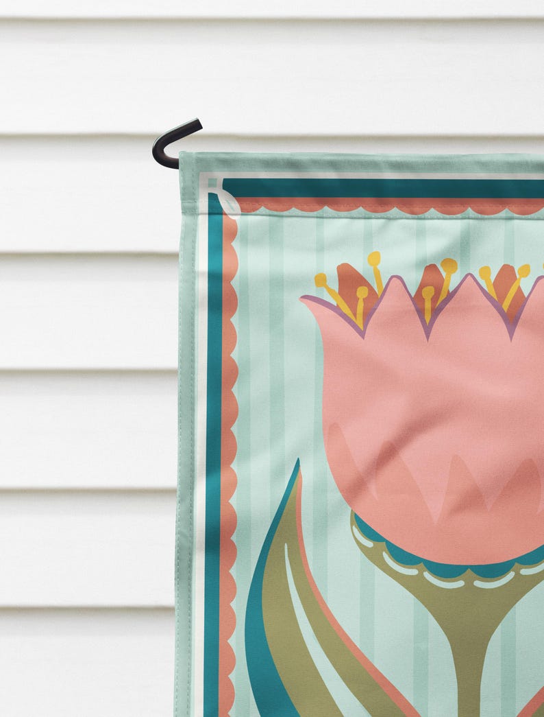 Peut inclure: Un drapeau de jardin d&eacute;coratif avec un motif de tulipe rose. Le drapeau a un fond &agrave; rayures bleu clair avec des accents turquoise et corail. Un crochet en m&eacute;tal noir est attach&eacute; pour l'accrocher.