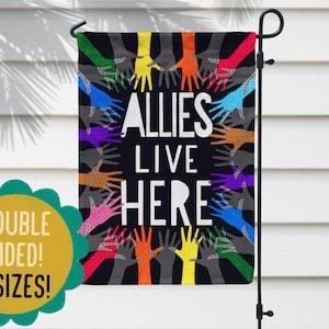 May include: A black garden flag with a circle of colourful hands reaching out. The text "ALLIES LIVE HERE" is in the centre of the circle.