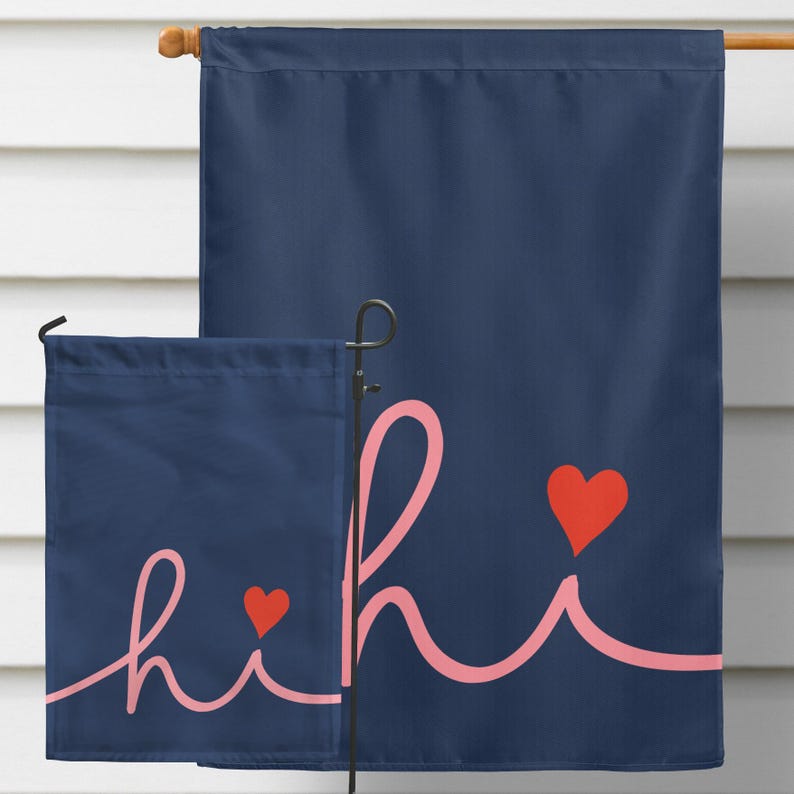 Pode incluir: Bandeira de jardim azul marinho com a palavra "hi" em fonte cursiva rosa claro e dois cora&ccedil;&otilde;es vermelhos. A bandeira &eacute; exibida em um suporte de metal preto, perfeita para decora&ccedil;&atilde;o ao ar livre.