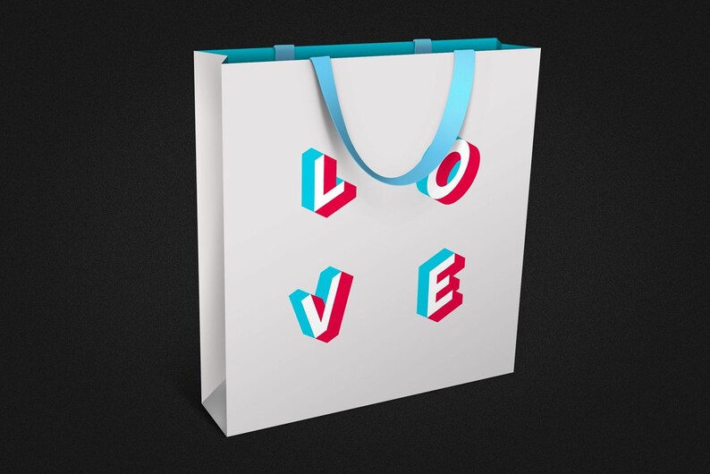 Puede incluir: Una bolsa de papel blanca con asas azules y la palabra "LOVE" impresa en la parte delantera en 3D, en letras azules y rojas.