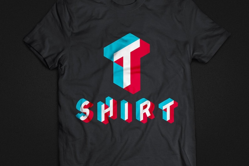Puede incluir: Una camiseta negra con un dise&ntilde;o 3D de la palabra "SHIRT" en azul, rojo y blanco. La "T" de "SHIRT" es m&aacute;s grande que las otras letras y est&aacute; en el centro de la camiseta.