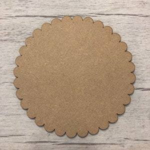 May include: A brown scalloped circle made of wood. The circle is approximately 20 cm in diameter.