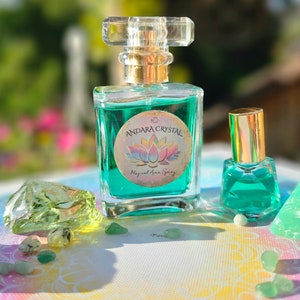 Puede incluir: Dos botellas de vidrio de l&iacute;quido verde con tapas doradas y etiquetas que dicen "Andara Crystal Magical Aura Spray". Las botellas est&aacute;n sobre una superficie blanca con cristales verdes.