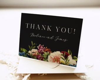 以下が含まれることがあります： 黒い「ありがとう」カードに、白い文字で「Thank You! Melanie and James」と書いてあります。カードは、カラフルな花で飾られた花柄の縁取りがされています。