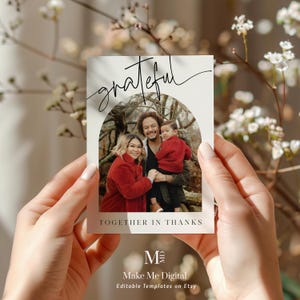 May include: A white card with a black handwritten word "grateful" at the top. The card has a photo of a family of three in a forest setting. The text "Together in Thanks" is below the photo. The card has a logo at the bottom that says "Make Me Digital" and "Editable Templates on Etsy".