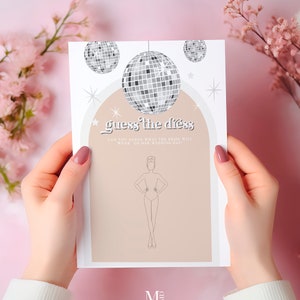 May include: A printable wedding game card with a disco ball theme. The card has a silhouette of a person and the text "guess the dress" with the tagline "Can you guess what the bride will wear on her wedding day?"