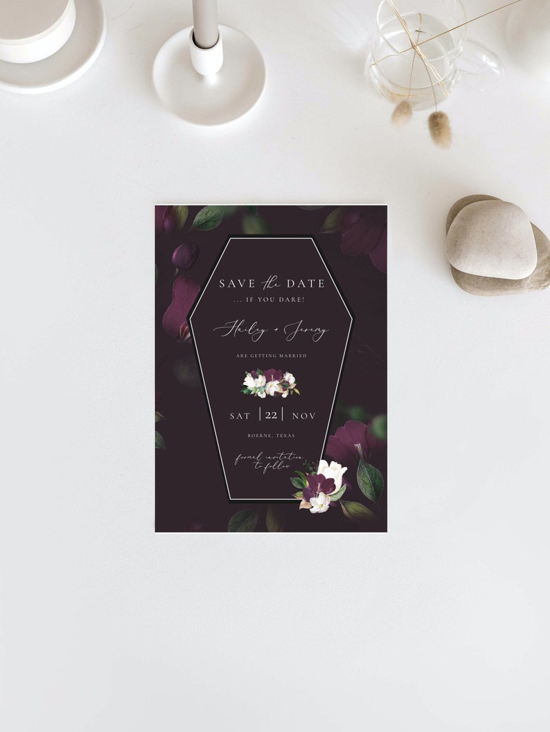 May include: A black and purple save the date card with a coffin-shaped frame. The text reads "Save the Date... If you dare!"  "Hilary & Jering are getting married"  "Sat 22 Nov"  "Boerne, Texas"  "Formal invitation to follow"