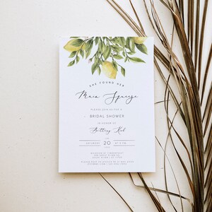 May include: A white bridal shower invitation with a watercolor illustration of lemons and leaves. The text reads "She found her Main Squeeze" and includes the bride's name, date, time, and location.