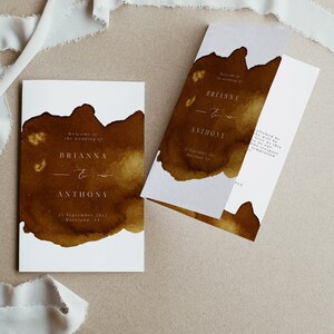 May include: A wedding invitation with a brown watercolour background. The invitation reads "Welcome to the wedding of Brianna & Anthony" and includes the date "25 September 2022" and the location "Maryland, NY".