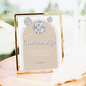 Puede incluir: Un cartel con marco dorado, fondo beige y borde blanco. El cartel presenta tres bolas de discoteca plateadas y el texto "Custom sign" en una fuente retro. El texto debajo dice "8 x 10 inch sign to make your own custom signs. Enjoy!"