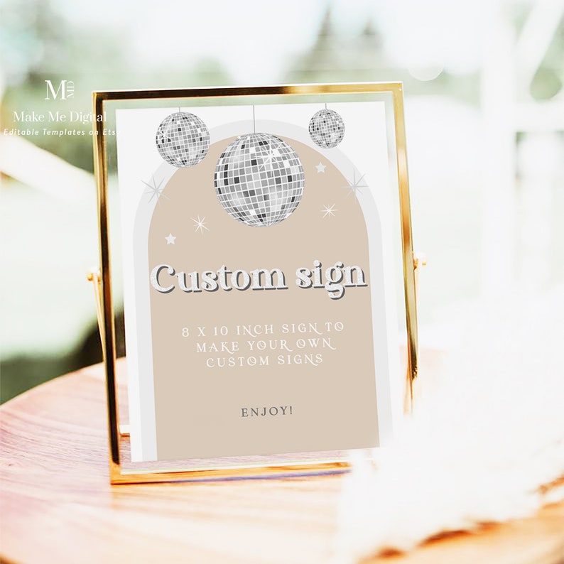 Puede incluir: Un cartel con marco dorado, fondo beige y borde blanco. El cartel presenta tres bolas de discoteca plateadas y el texto "Custom sign" en una fuente retro. El texto debajo dice "8 x 10 inch sign to make your own custom signs. Enjoy!"