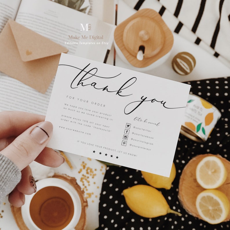 May include: A white thank you card with black text. The card says "Thank you" in a script font and includes the text "For your order" and "We hope you love your product as much as we loved creating it!" The card also includes social media icons and the text "Let's be social" and "If you love your product, let us know!" The card is sitting on a table with a cup of tea, lemons, and a wooden box.