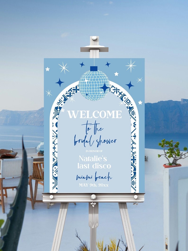 May include: A blue and white welcome sign for a bridal shower with a disco ball and stars. The text reads "Welcome to the bridal shower in honor of Natalie's last disco Miami Beach May 9th, 20xx".