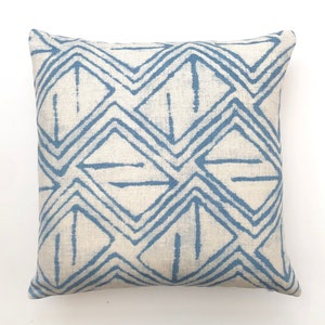 May include: A blue and white geometric patterned throw pillow. The pillow is made of a soft, natural fabric and features a repeating diamond pattern.