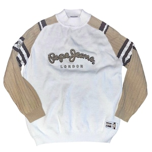 May include: White knit sweater with tan sleeves and a ribbed collar. The sweater features the text "Pepe Jeans London" in a script font across the chest. The sleeves have dark brown and white stripes.