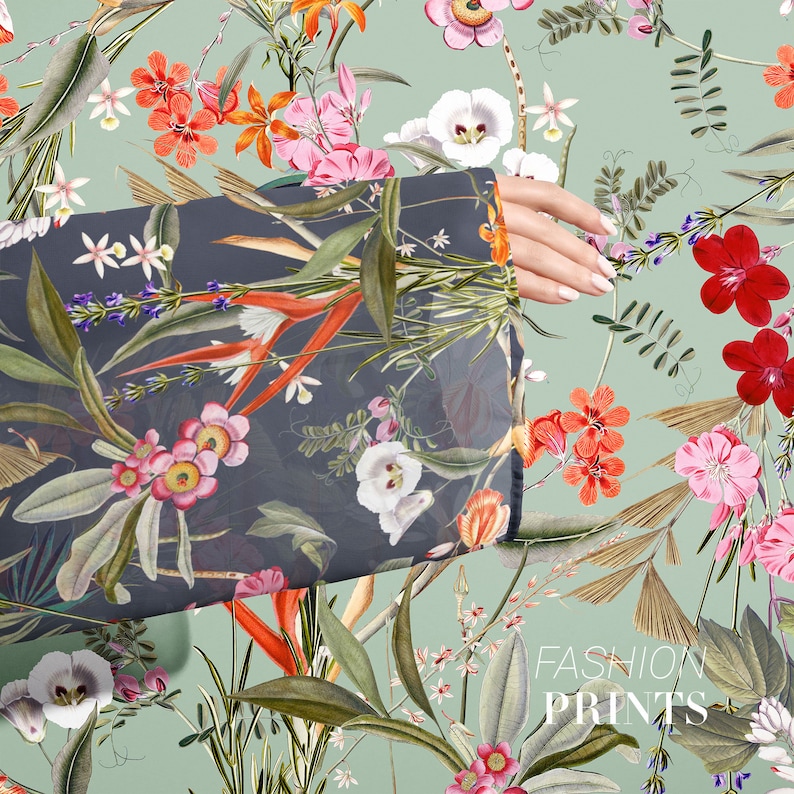 May include: A dark gray fabric with a floral print featuring red, pink, and white flowers, green leaves, and orange and yellow accents. The fabric is draped over a hand and the text "FASHION PRINTS" is visible in the bottom right corner.
