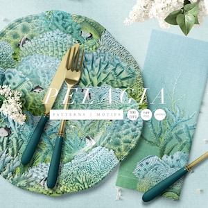 May include: A round plate and a rectangular napkin featuring a teal and green coral reef pattern with small fish. A gold-toned knife and fork with teal handles rest on the plate, and a matching knife lies on the napkin. Text reads PELAGIA.