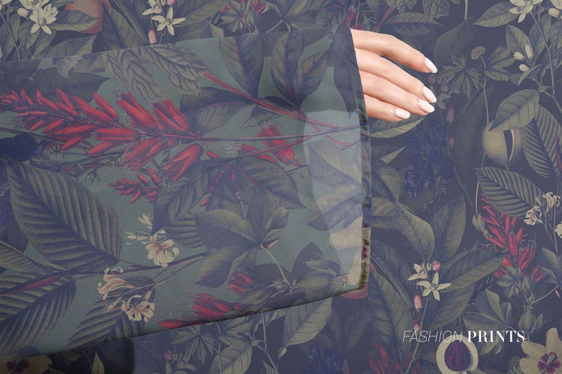 Puede incluir: Una tela verde y azul con un estampado floral que presenta flores rojas, hojas verdes y una flor blanca. La tela es transparente y tiene una mano que sale del lado.