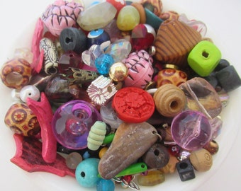 May include: A large assortment of colorful beads, including wood, glass, and plastic. The beads are in various shapes and sizes, and some have intricate designs.