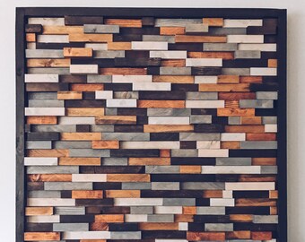 May include: A framed wall art piece made of various wood planks in different shades of brown, gray, and white. The planks are arranged in a staggered pattern to create a textured and modern look.