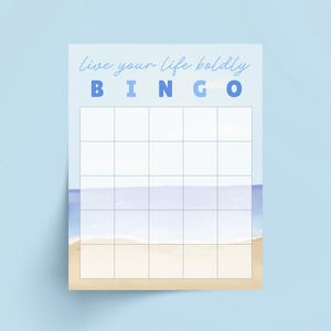 May include: A light blue Bingo card with the words "live your life boldly" and the word "BINGO" in blue letters. The bottom of the card features a watercolor beach scene with sand and ocean. The card has a grid of blank squares.