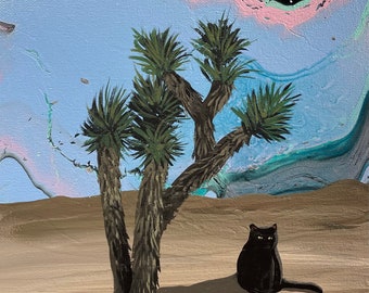 Op de afbeelding: Een zwarte kat zit in een woestijnlandschap met een Joshua-boom op de voorgrond. De lucht is lichtblauw met een roze en groene nevel op de achtergrond.
