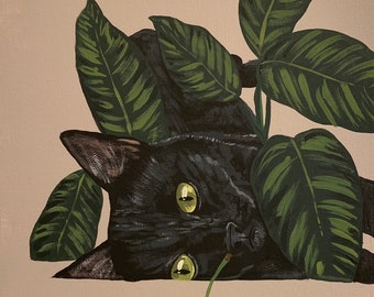 May include: A black cat with green eyes peeks out from behind a leafy green plant. A single red cherry sits on a light beige surface in front of the cat.