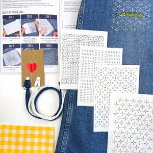 May include: A denim repair kit with various stitch patterns, needles, and thread. The kit includes instructions and pre-printed designs for mending and upcycling clothing. A yellow and white checkered fabric is also included.