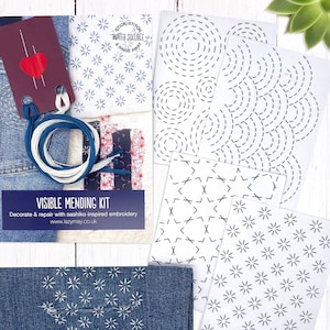 May include: A visible mending kit with water-soluble fabric for sashiko embroidery. The kit includes a variety of stitch patterns, including circles, stars, and geometric shapes. The kit also includes embroidery floss in blue and white.