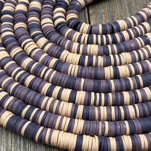 May include: A close-up of a strand of round, flat, ceramic beads. The beads are alternating colors of beige and dark purple.