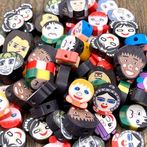 May include: A collection of colorful, hand-painted polymer clay beads featuring various cartoon faces. The beads are round and have a hole in the center for stringing. The beads are a mix of different colors, including red, blue, green, yellow, and black.