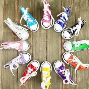 May include: A circle of twelve colorful canvas sneakers with white laces. The sneakers are arranged in a circle on a wooden surface.