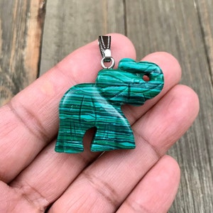 May include: Green and black striped malachite elephant pendant with a silver bail.
