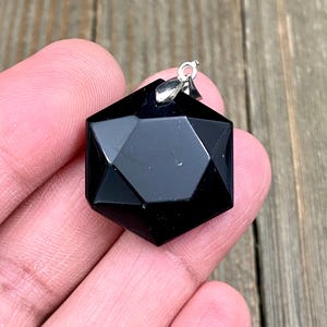 Op de afbeelding: Zwarte obsidianen ster van David hanger met een zilveren bedel.