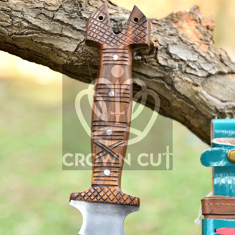 May include: A wooden-handled knife with a carved design. The handle is brown and has a unique shape. The blade is silver and has a pointed tip.