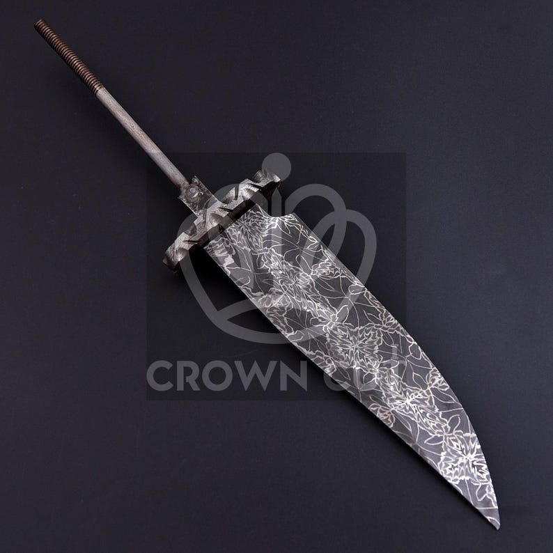 May include: A large, ornate metal blade with a floral pattern etched into the surface. The blade has a long, pointed tip and a wide, curved edge. The handle is a long, threaded rod. The blade is approximately 18 inches long.