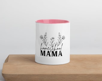 Puede incluir: Taza de cerámica blanca con borde rosa. La taza tiene un diseño floral negro y el texto "homeschool MAMA" impreso en ella.