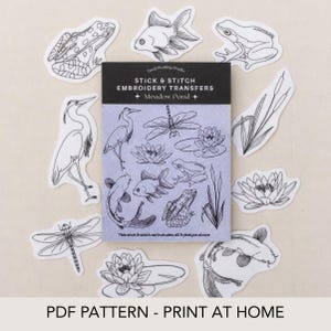 Op de afbeelding: Een set stick and stitch borduurtransfers genaamd Meadow Pond, met zwarte lijntekeningen van kikkers, vissen, libellen, waterlelies en riet. Het pakket bevat negen verschillende illustraties met een natuurthema voor borduurwerk.