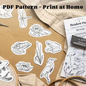 May include: A collection of black and white line art stickers featuring aquatic life, including fish, frogs, and water lilies. The phrase "PDF Pattern - Print at Home" is at the top. A sheet of "Meadow Pond" embroidery transfers is also visible.